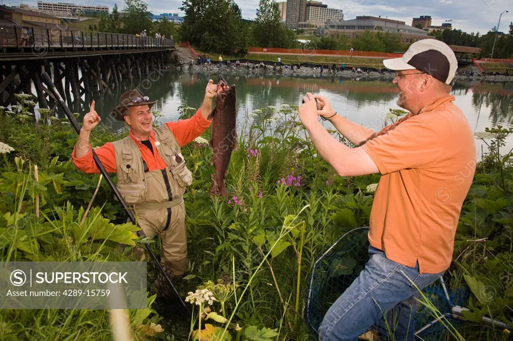 Fisherman poses with King Salmon at Ship Creek in downtown Anchorage, Alaska during Summer