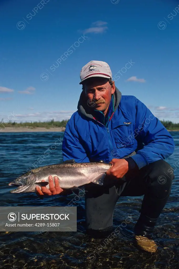 Fisherman holding Silver salmon caught on Kanektok River Southwest Alaska Summer