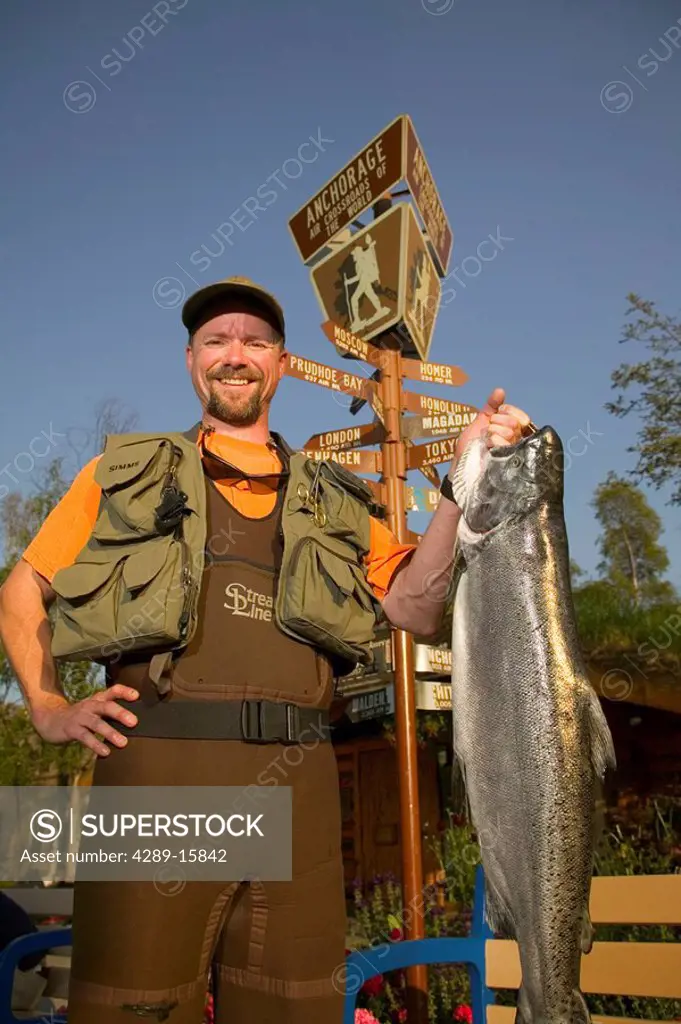 Man in Fishing Gear Holds King Salmon @ ACVB Digital AK SC Summer Anchorage