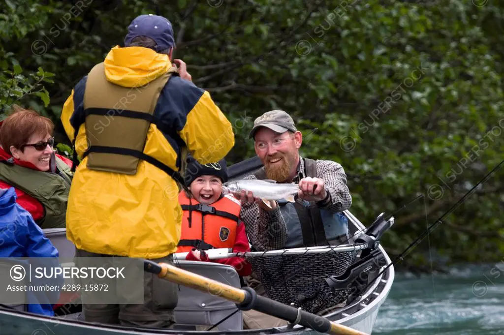 Guide holding Dolly Varden Trout for picture for family fishing on Kenai River Kenai Peninsula AK