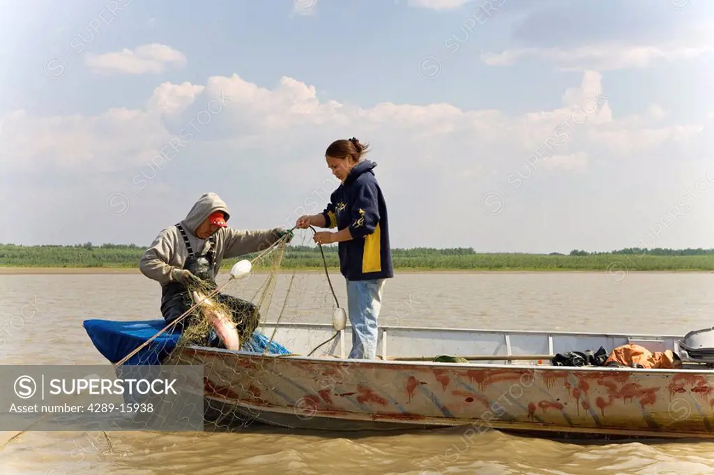 Native Yupik eskimo father & daughter subsistence drift netting for salmon Kuskokwim River WE Alaska