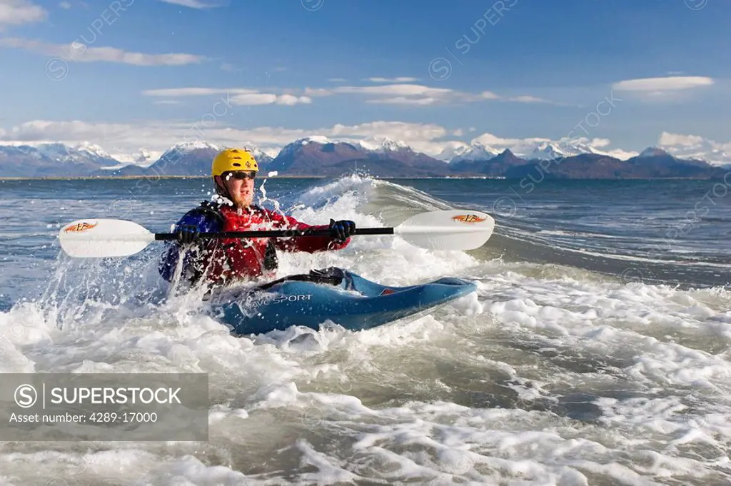 Man Kayak Surfing waves on Katchemak Bay near Homer Kenai Peninsula Alaska Autumn