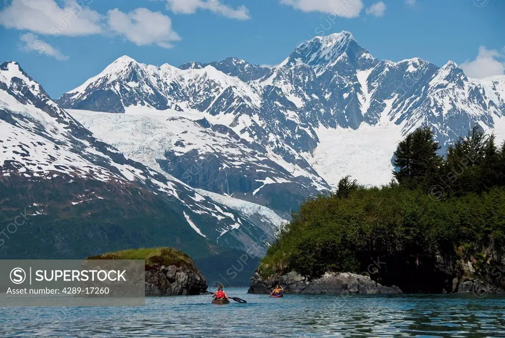 Kayakers paddling towards Black Sand Beach in Harriman Fjord, Chugach National Forest, Prince William Sound, Southcentral Alaska, Summer