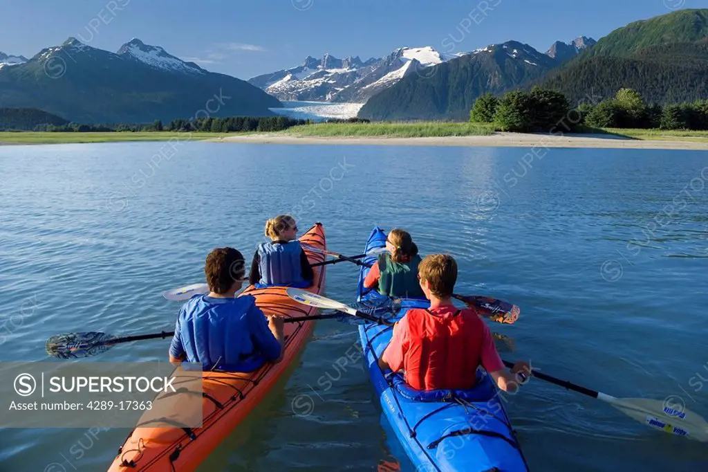 Kayakers kayaking in double sea_kayaks near Juneau in Inside Passage with view of Mendenhall Glacier Alaska