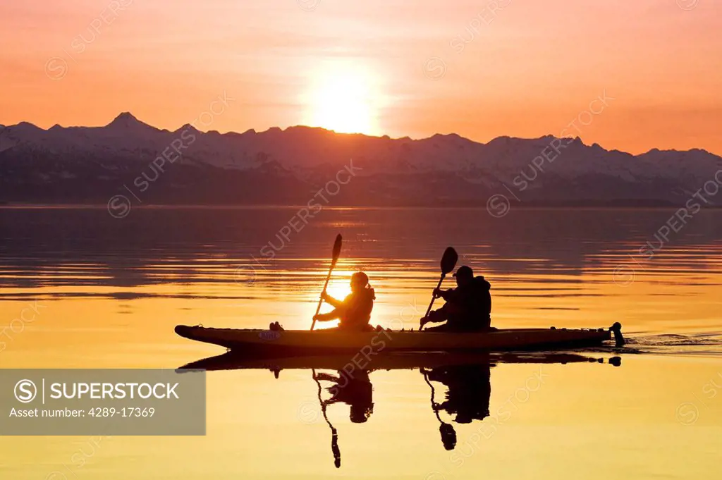 Kayakers paddle the calm waters of Alaska´s Lynn Canal at sunset with the Chilkat Mountains in the background, Tongass National Forest, Alaska