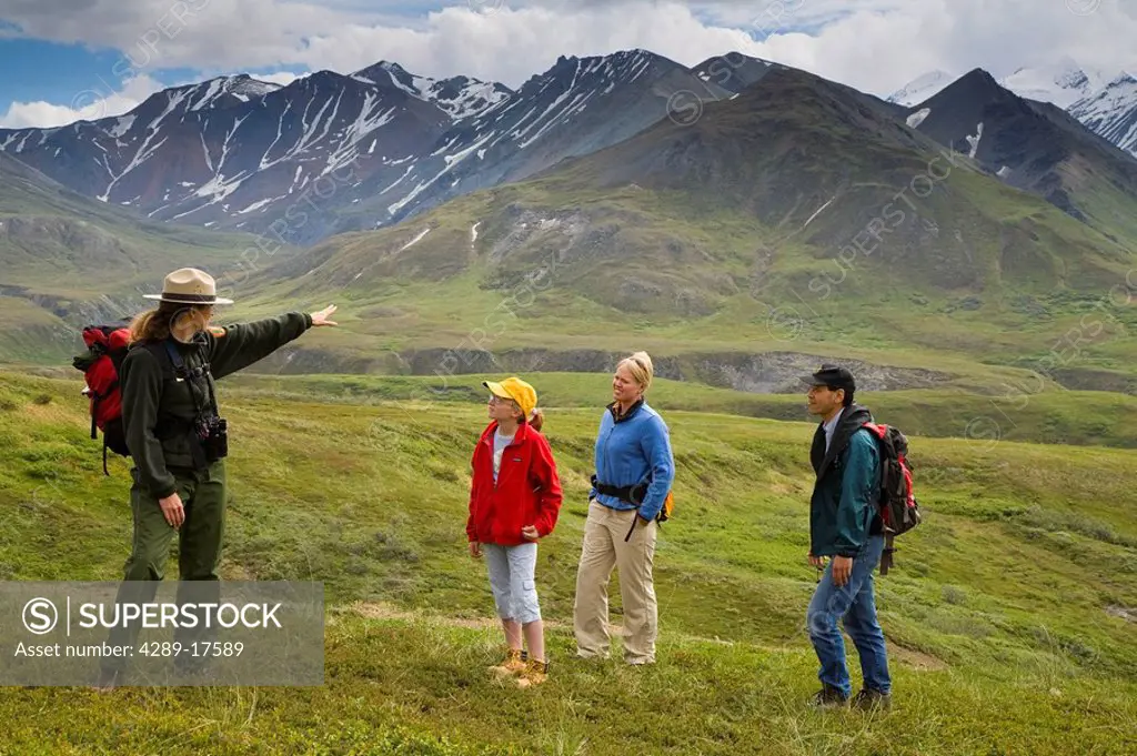 A woman US National Park Interpretive Ranger leades group on a *discovery hike* on the tundra Eielson area Denali National Park Alaska