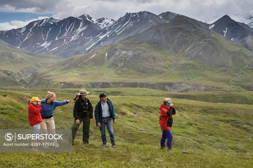 A woman US National Park Interpretive Ranger leades group on a *discovery hike* on the tundra Eielson area Denali National Park Alaska