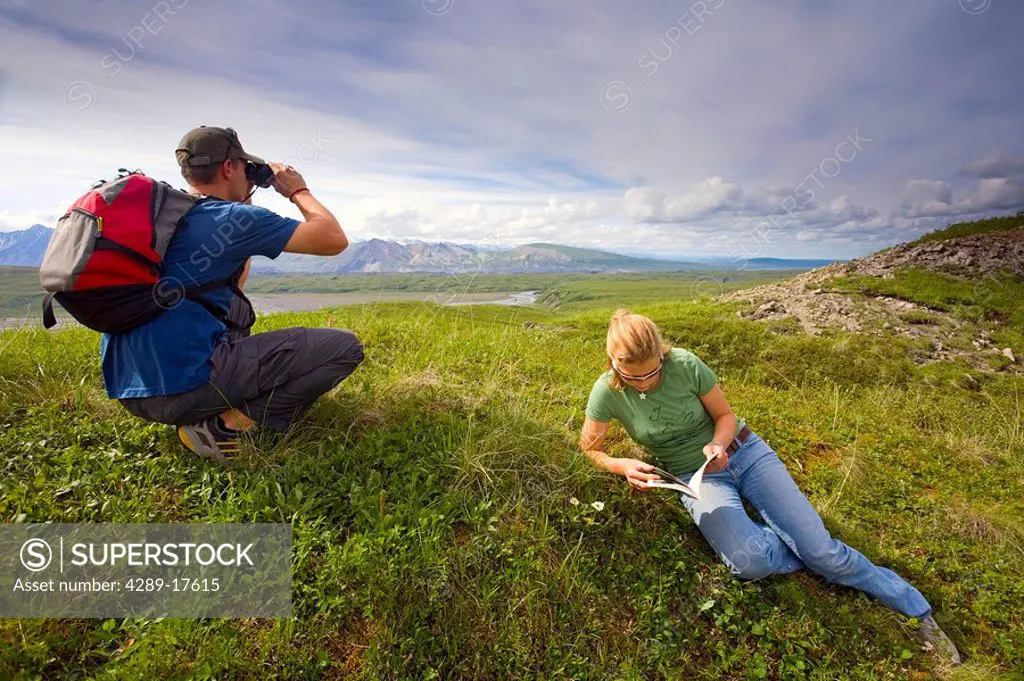Young couple views the landscape at Grassy Pass near Eielson Visitors Center Denali NP Alaska Summer
