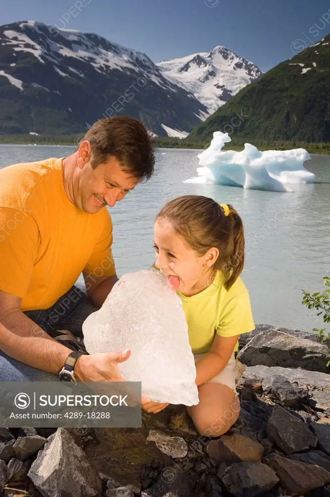 Family inspects chunk of ice from Portage Lake while out hiking Chugach National Forest SC Alaska