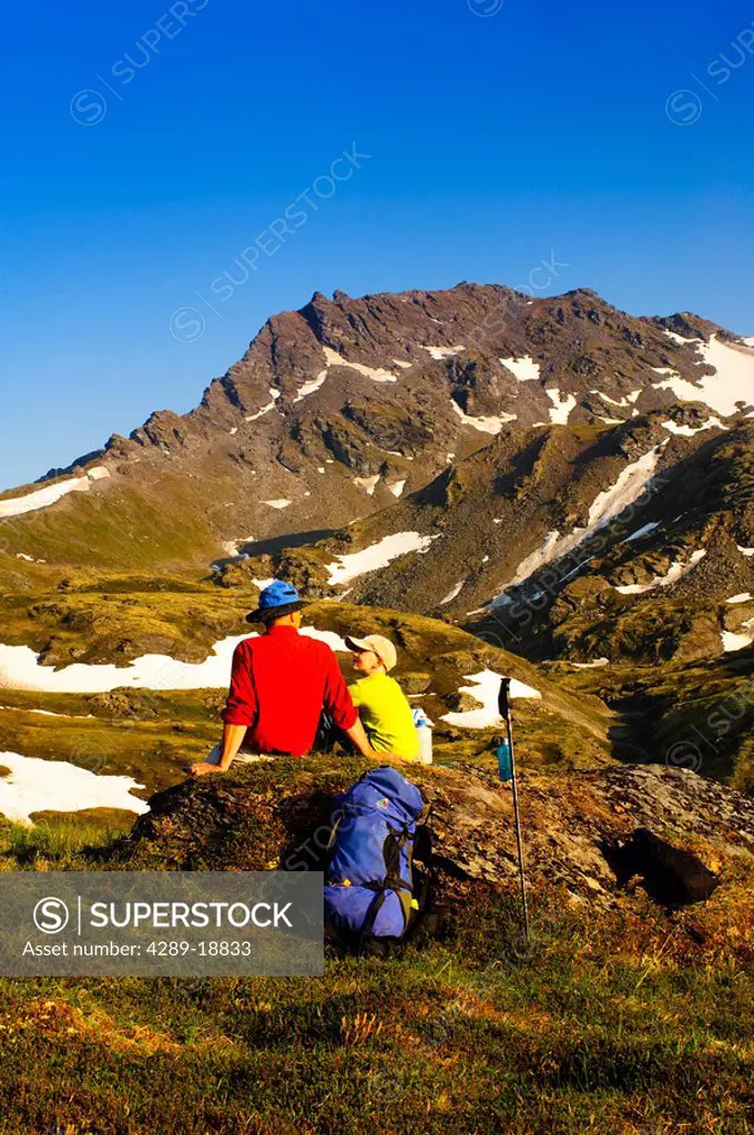 A father and son backpacking near Hatcher Pass in the Talkeetna Mountains with Bald Mountain Ridge in the background, Southcentral Alaska, Summer