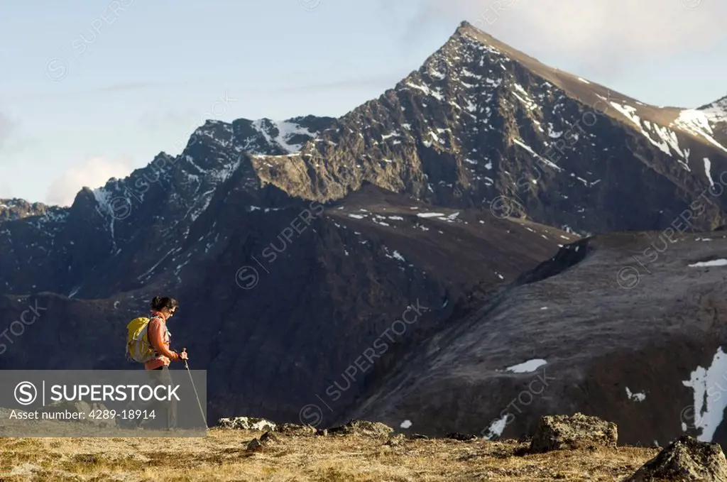 Woman hiking in Chugach State Park with *The Ramp* peak in the background, Southcentral, Alaska