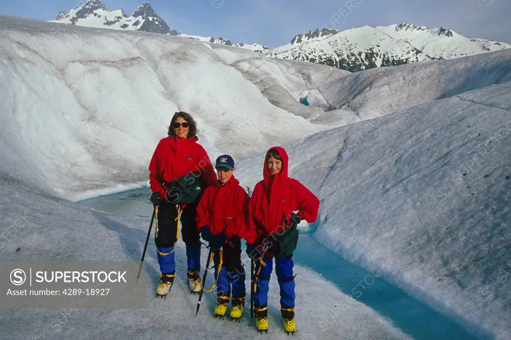 Mother & children equipped w/crampons hiking on Mendenhall Glacier Coast Mtns Southeast AK Winter