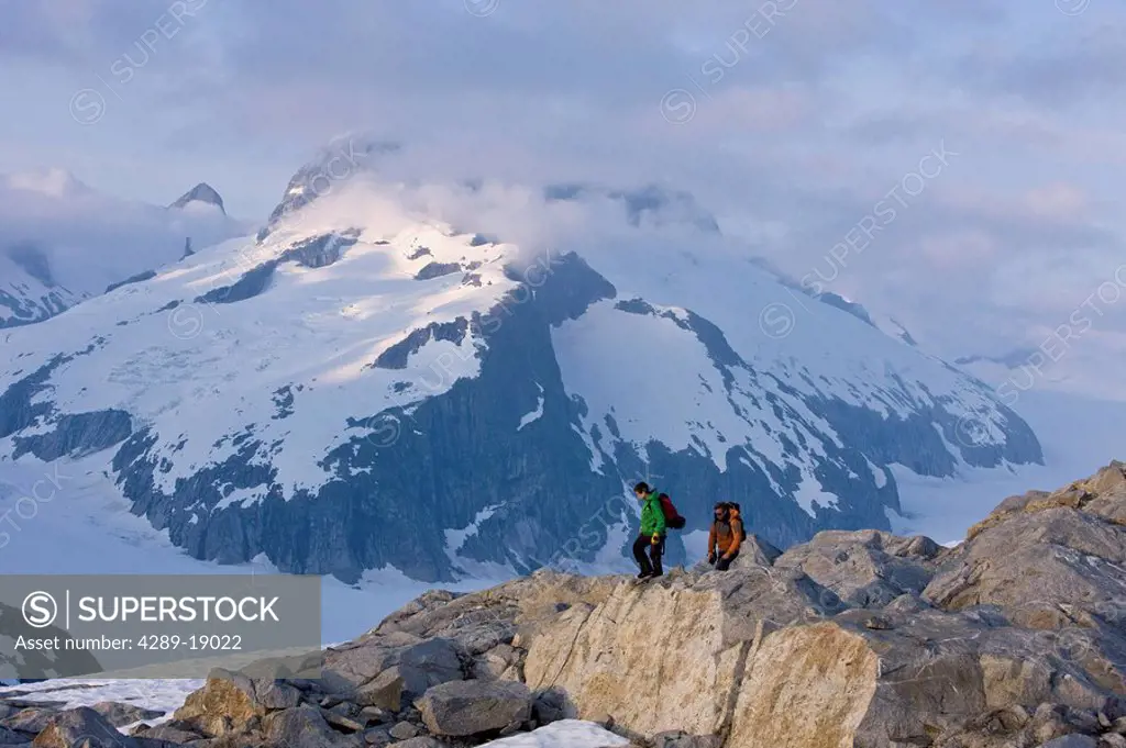 Hikers climb in the afternoon sun on a ridge above the Juneau Ice Field, Juneau, Alaskain the Tongass National Forest