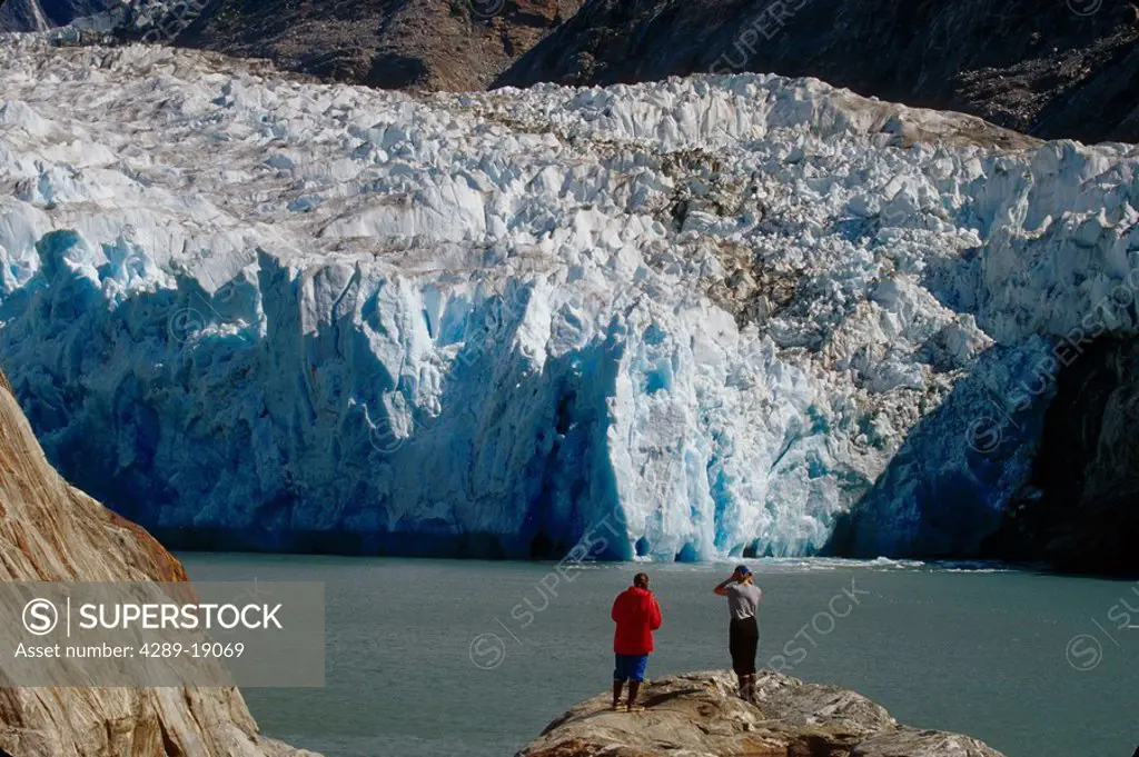 Hikers Stand On Rock And Watch S.Sawyer Glacier AK SE Tracy Arm Fords Terror Wilderness Area