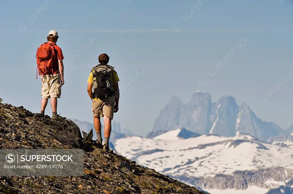 Two hikers take in the view of the Devil´s Paw and the Juneau Ice field from the Mt. Juneau ridgeline near Juneau in southeast Alaska