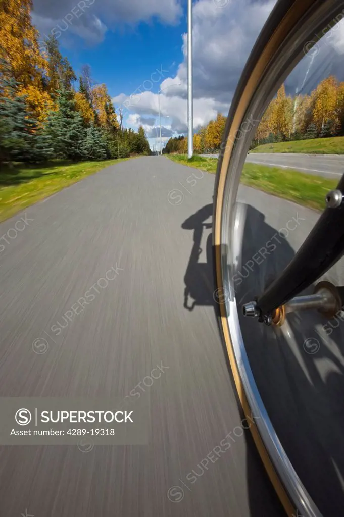 Wide angle view of a biycle tire in motion on a bike path in Anchorage, Southcentral Alaska, Autumn
