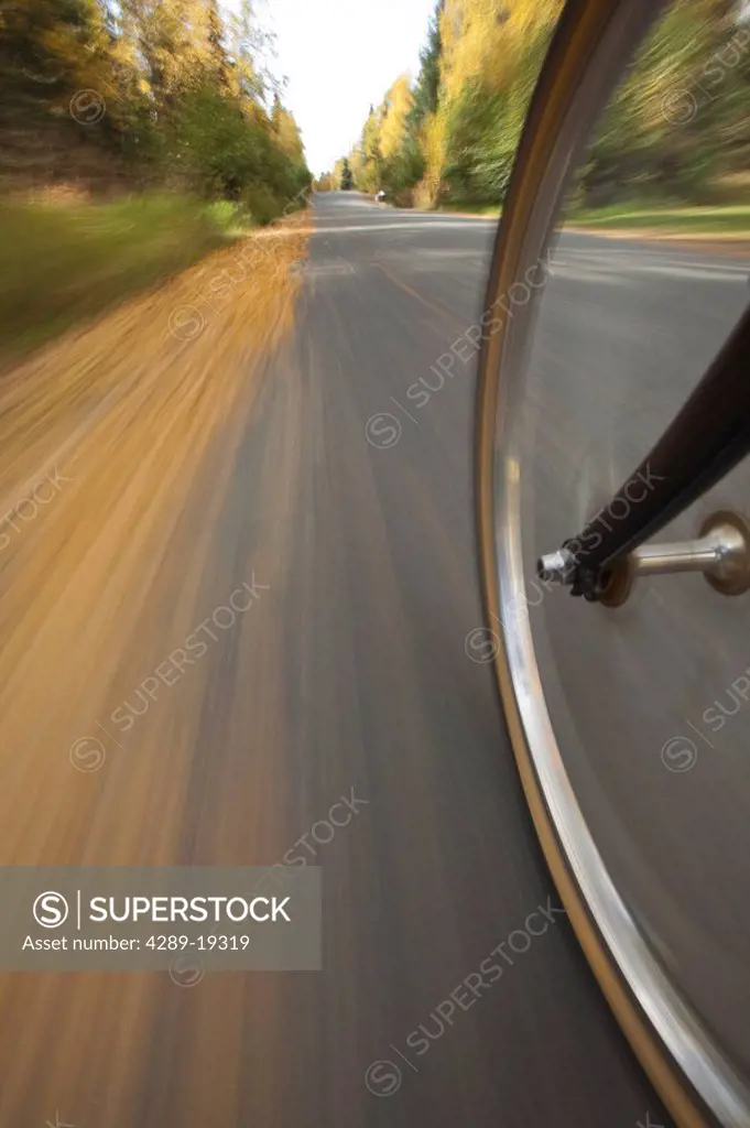 Wide angle view of a biycle tire in motion on a bike path in Anchorage, Southcentral Alaska, Autumn