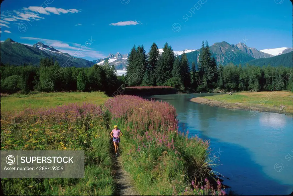 Woman jogging Mendenhall Glacier & River Southeast AK summer scenic