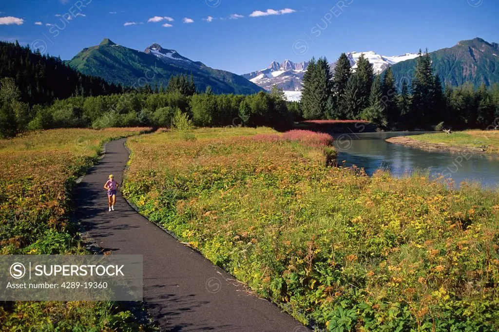 Woman jogging Mendenhall Glacier & River Southeast AK summer scenic