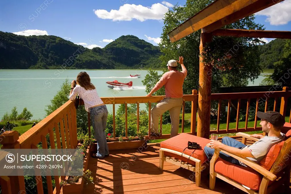 Guests of Redoubt Bay Lodge relax on the deck of the main lodge and watch a Rust´s Flying Service plane take off from Big River Lake. Redoubt Bay Stat...