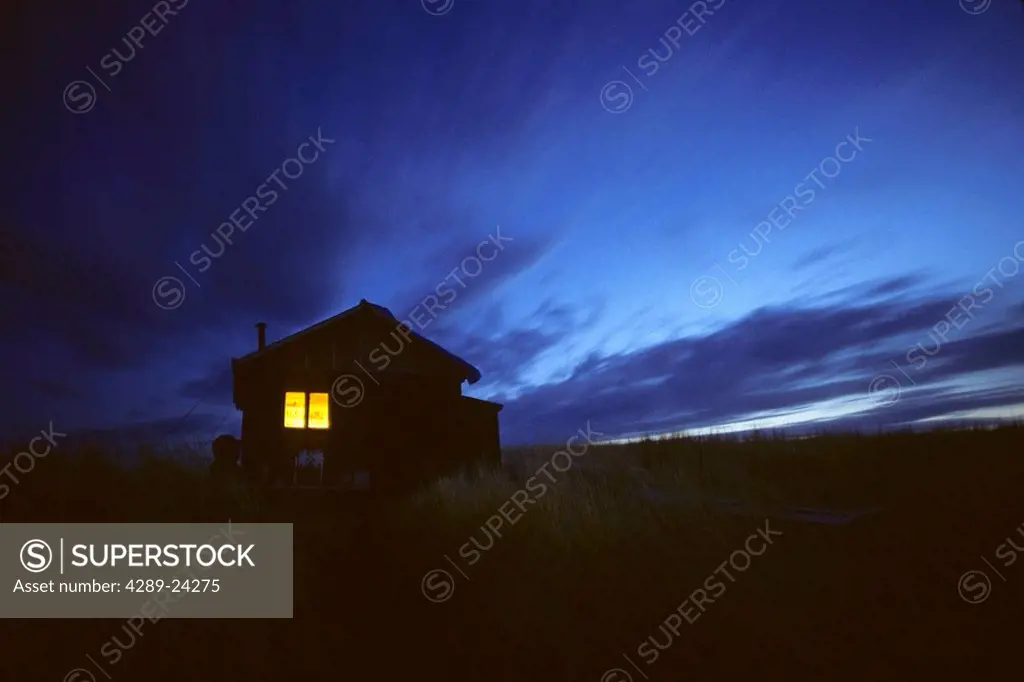 Cabin lit by lantern Kodiak Isl Southwest AK summer scenic