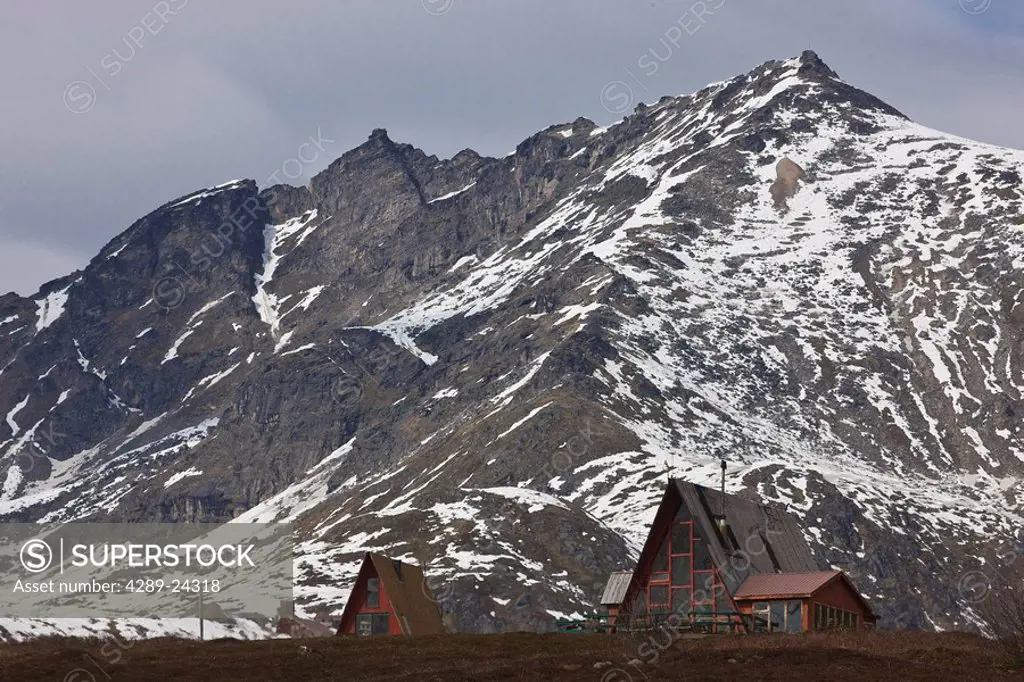 A_Frame chalet at Hatcher Pass with the last of the spring snow on the surrounding Talkeetna mountains, Southcentral Alaska