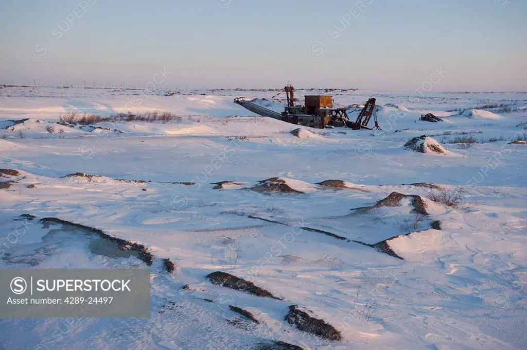 Historical gold dredge sits on snowcovered tundra near Nome, Alaska