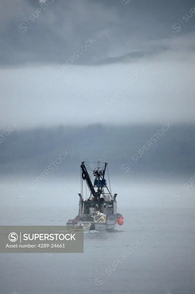 Commercial salmon fishing boat in heavy fog Port Valdez Southcentral Alaska Summer
