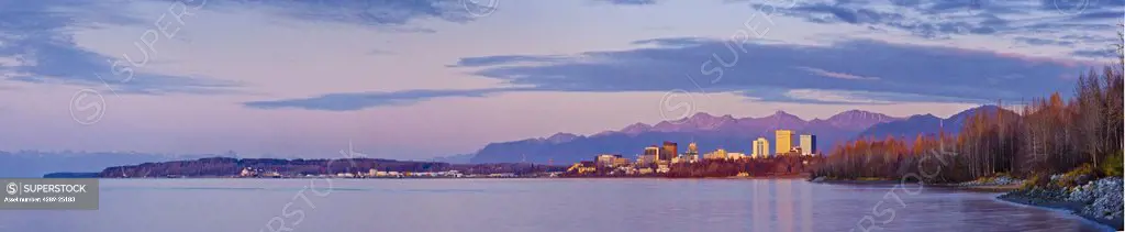 Sunset view of the Anchorage skyline reflecting in the waters of Cook Inlet and Knik Arm, Southcentral Alaska, Fall