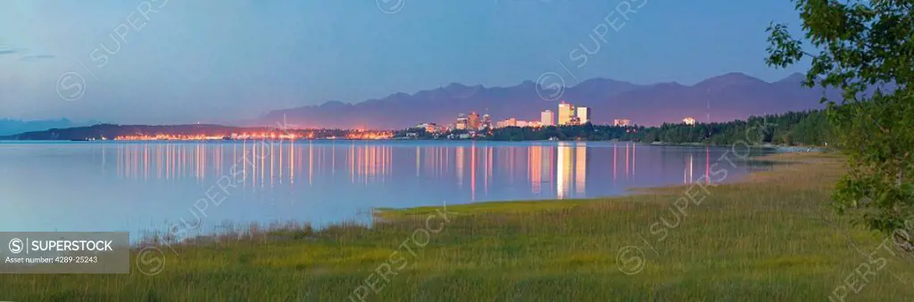 View of downtown Anchorage skyline across Knik Arm w/reflection @ sunset Southcentral Alaska Summer