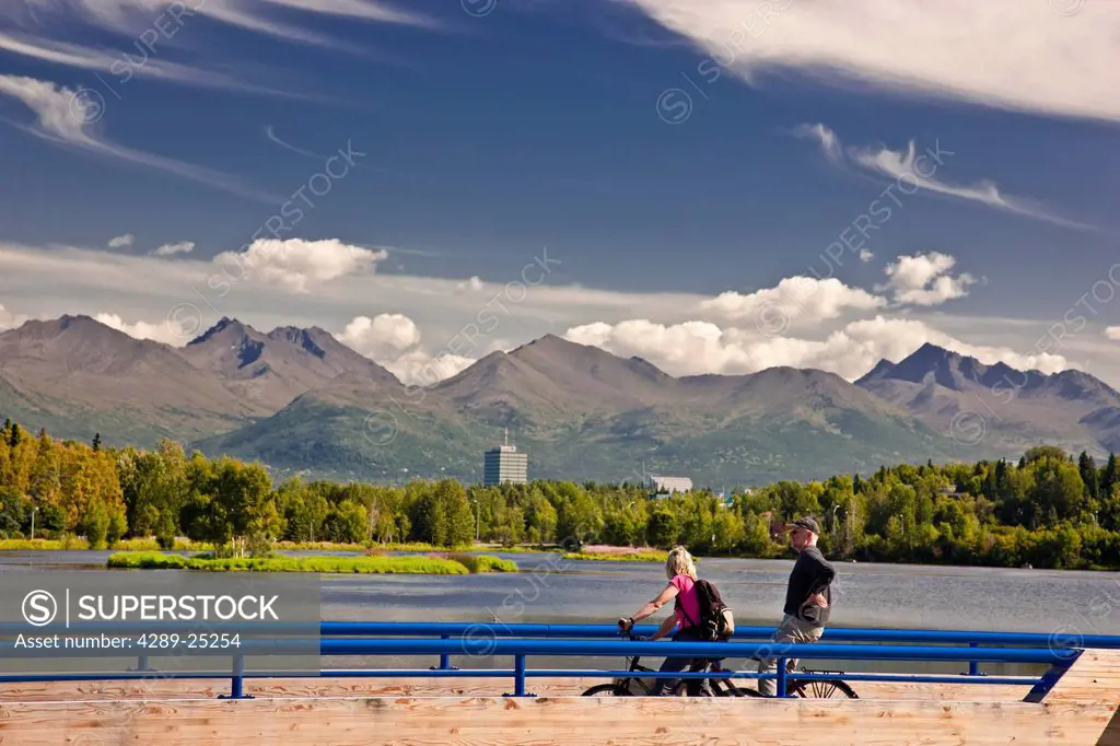Bikers overlooking Westchester Lagoon from the Tony Knowles Coastal Trail during Summer, Anchorage Southcentral Alaska