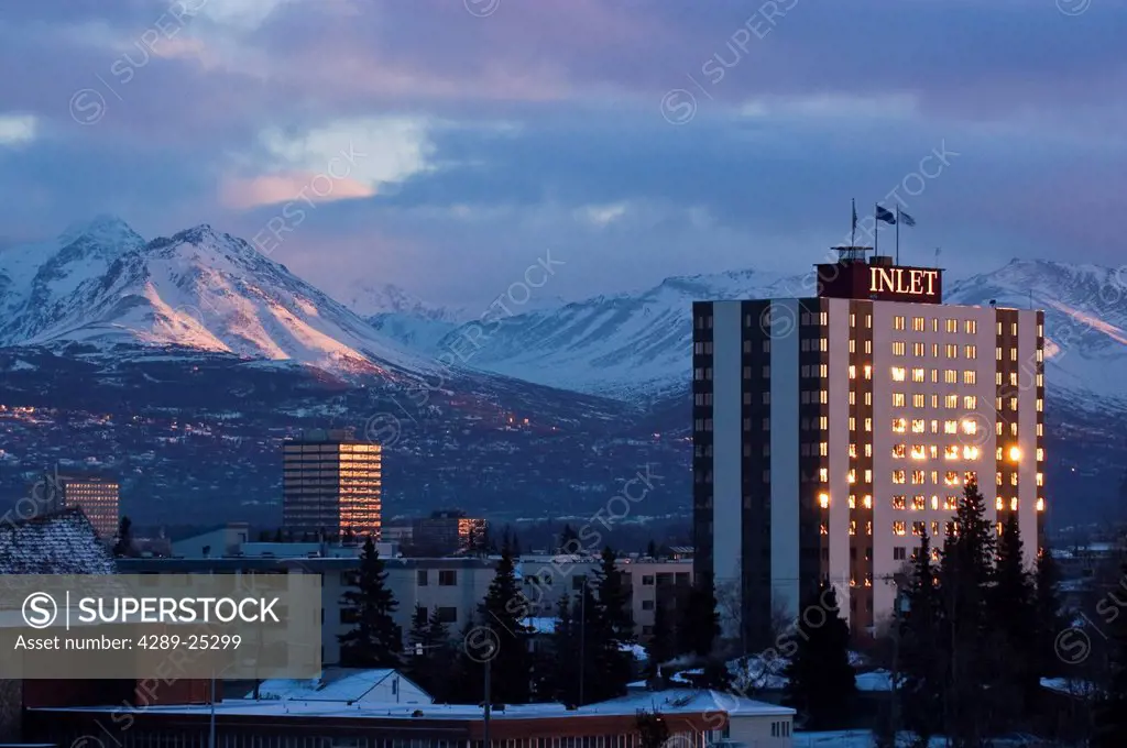 View of Inlet Towers Hotel and downtown Anchorage with the Chugach Mountains in the background, Southcentral Alaska, Winter/n