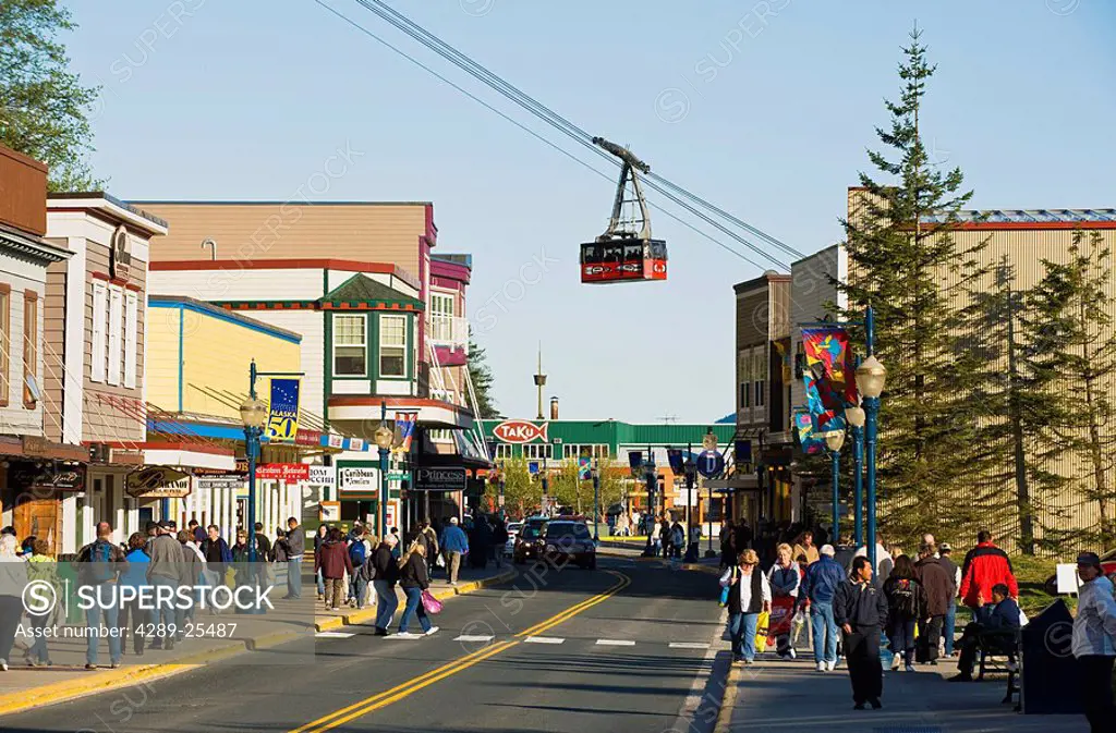 Tourists crowd South Franklin Street as a Mount Roberts tram car passes overhead in Downtown Juneau, Southeast Alaska