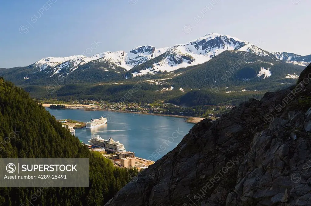 A hiker takes in the view of Gastineau Channel, Mt. Jumbo, and Downtown Juneau from the side of Mt. Roberts in Southeast Alaska during Summer