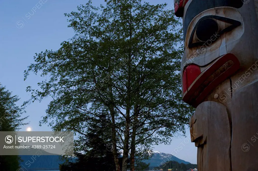 Moonrise over Sitka with a totem pole in the foreground in Southeast, Alaska