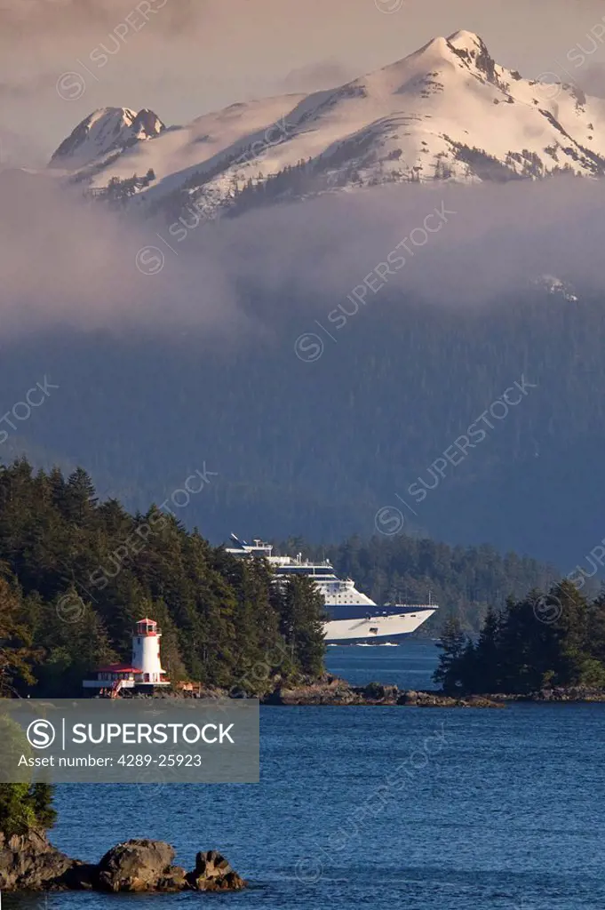 Celebrity cruise ship Infinity navigates between islands with the Rockwell lighthouse near Sitka, Alaska