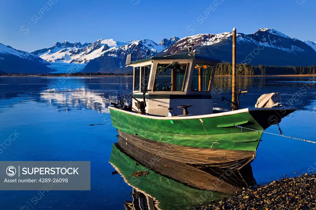Scenic view of a fishing boat moored on the shore of Gastineau Channel with Mendenhall Glacier and the Coast Mountains in the background, Inside Passa...