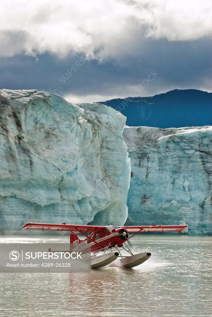 A DeHavilland Beaver takes off from Strandline Lake at the edge of the Triumvirate Glacier in the Tordrillo Mountains, Southcentral Alaska, Fall