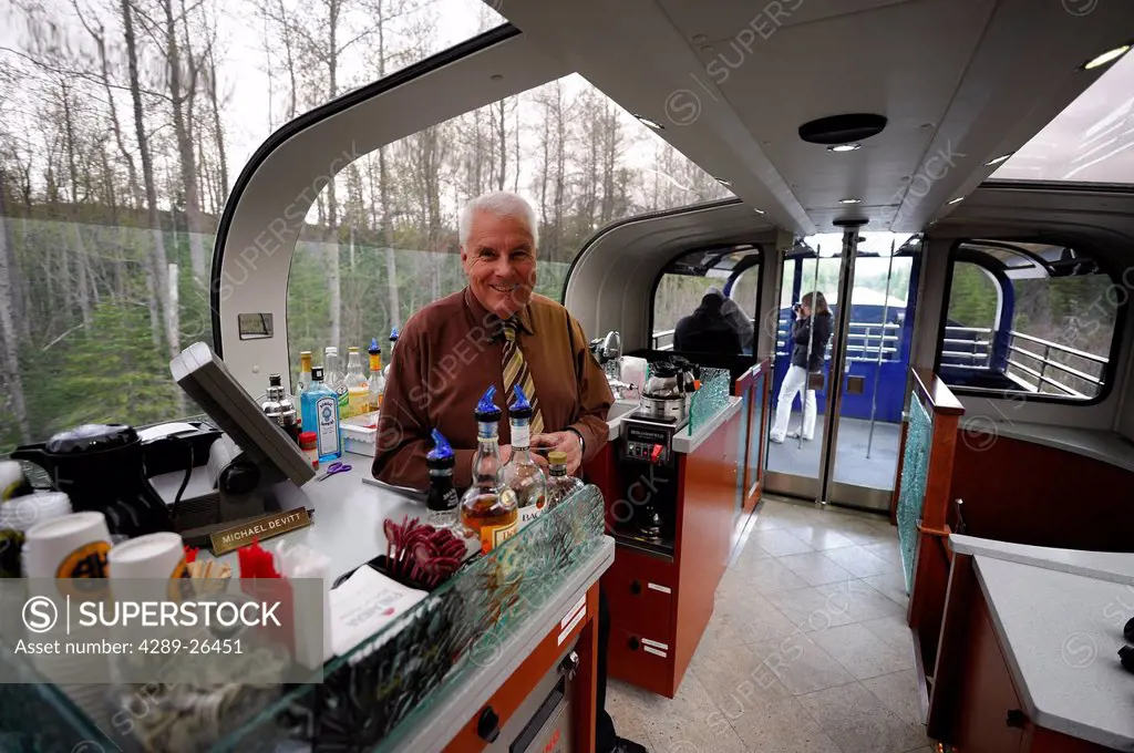Male waiter serves refreshments for first_class passengers on the Alaska Railroad´s Goldstar service between Anchorage and Seward, Southcentral Alaska...
