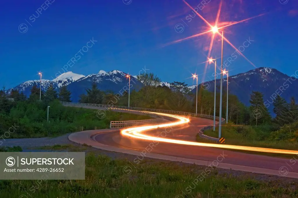 Traffic lights blur going over a bridge near Sitka, Alaska at dusk