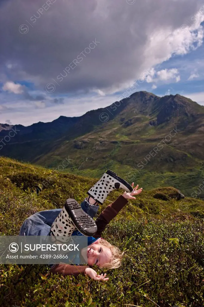 Young girl playing on a hillside in Hatcher Pass, Southcentral Alaska