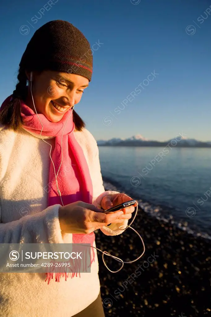 Woman listens to iPod at Bishops Beach at Kachemak Bay in Homer, Alaska