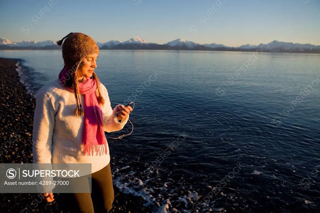 Woman listens to iPod at Bishops Beach at Kachemak Bay in Homer, Alaska