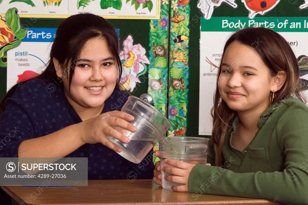Alaskan native girls in classroom setting Inside pouring water science