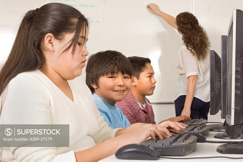 Alaskan native children in classroom work @ computers w/teacher inside Alaska