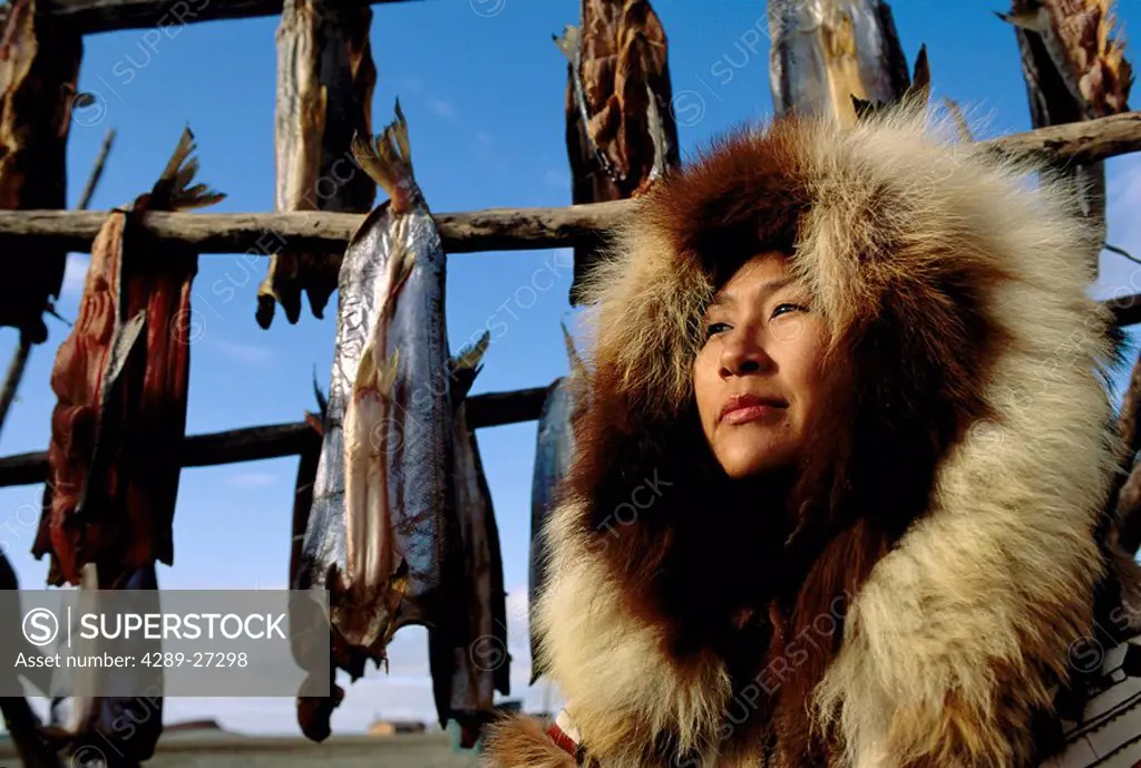 Alaskan Native Eskimo woman & fish drying rack Kotzebue/nAlaska Summer Fur parka