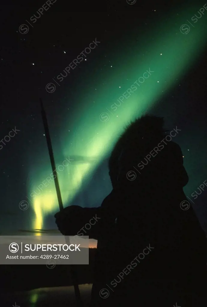 Eskimo man viewing Northern lights Alaska composite scenic