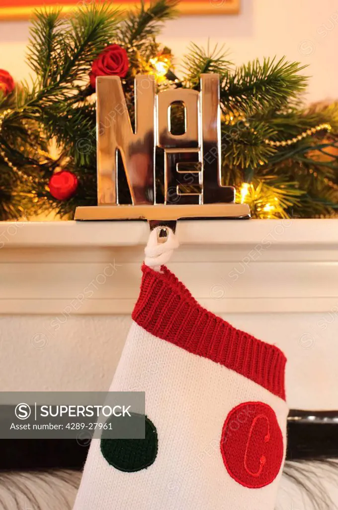 Stocking hanging from the mantel of a fireplace decorated for Christmas