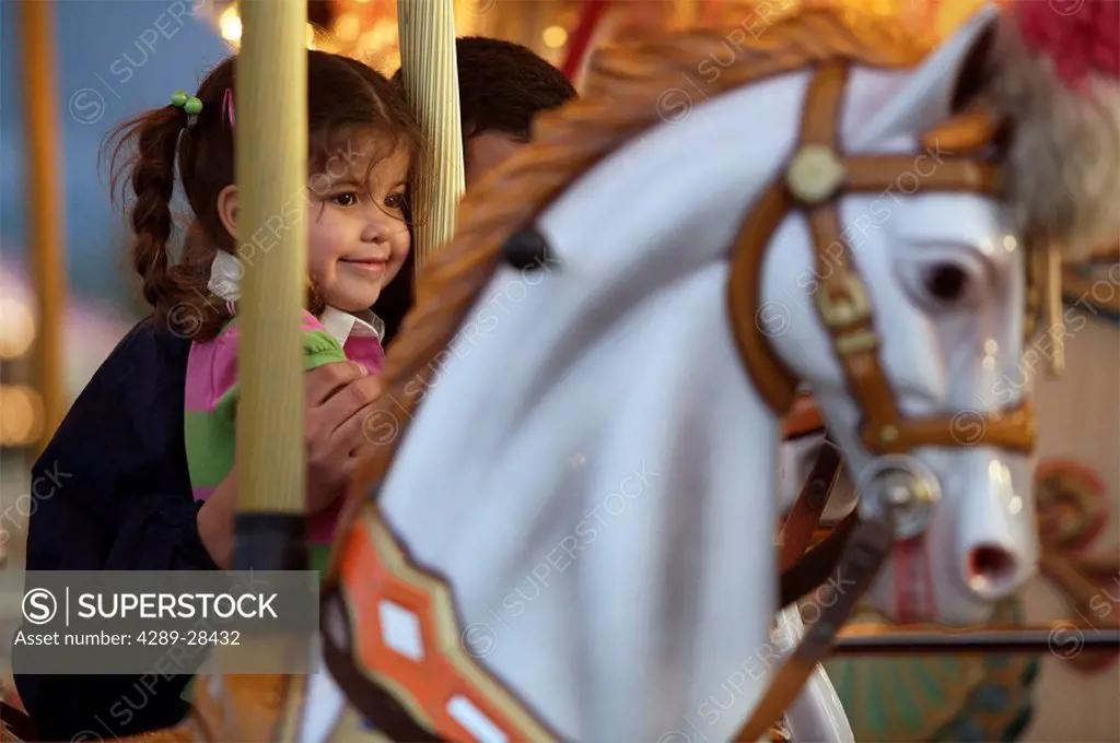 Young girl riding horse carousel at Alaska State Fair Palmer Alaska