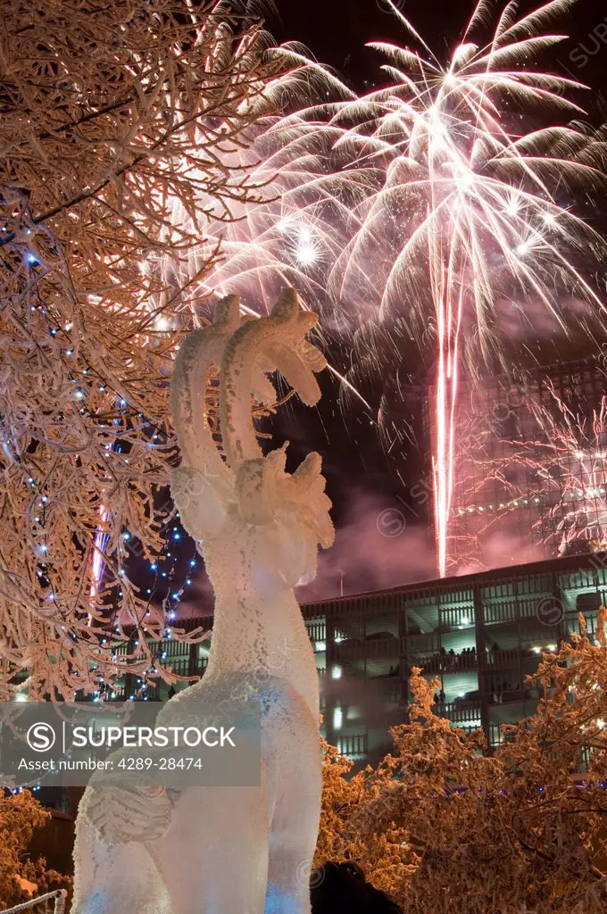 Hoar frost covered caribou ice sculpure in Town Square Park with fireworks overhead during the 50th Anniversary Statehood celebration in Downtown Anch...